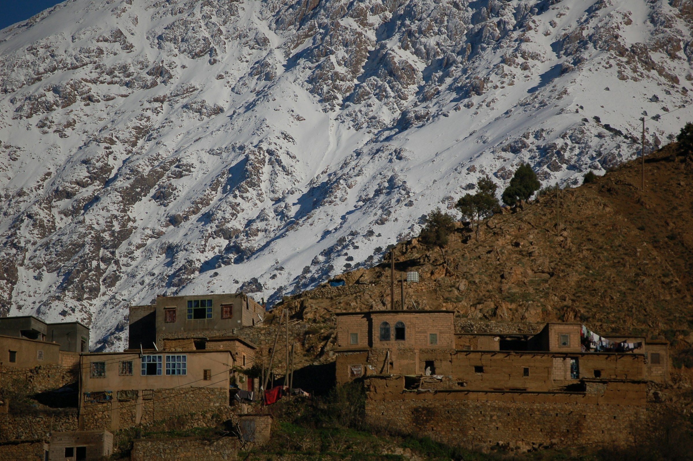 Un village de montagne au pied des sommets enneigés de l'Atlas