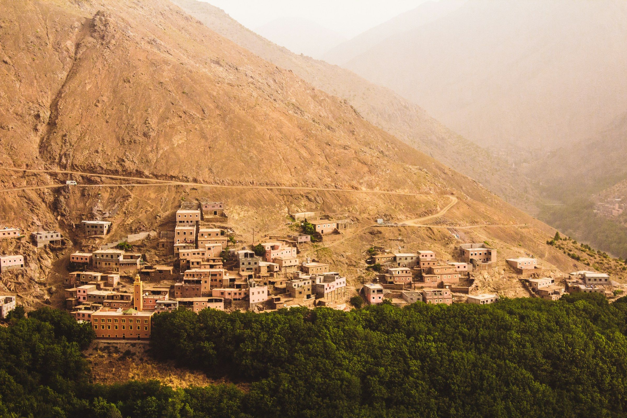 Un village accroché à la montagne, au-dessus d’une vallée verdoyante